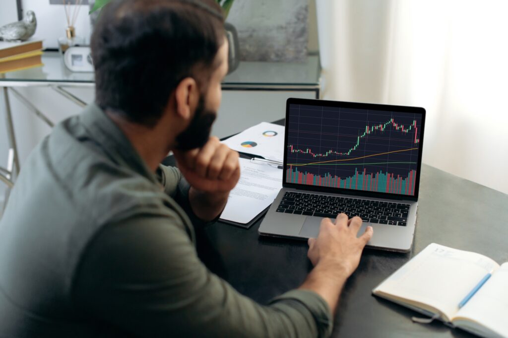 Smart broker investor, uses a laptop to analyze the financial market of cryptocurrencies, invests in